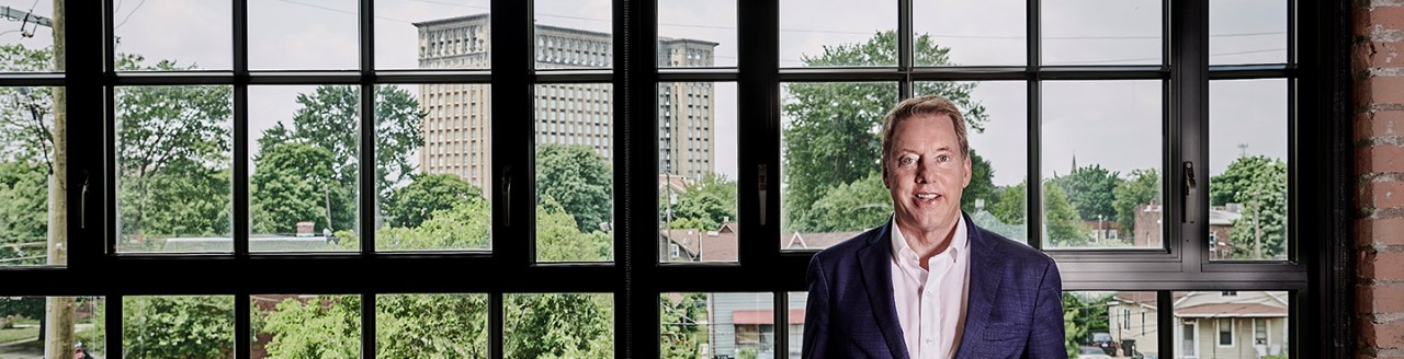 Bill Ford standing in front of windows in a Corktown building