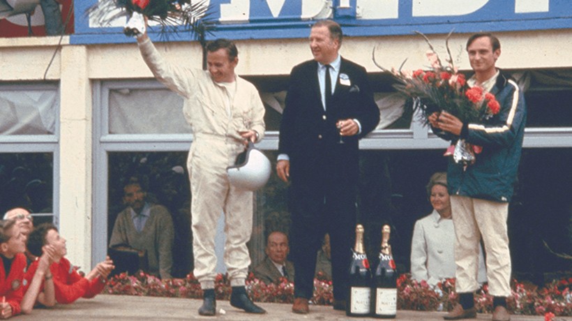 Bruce McLaren, Henry Ford II, and Chris Amon on victory rostrum after 24 Hours of Le Mans 1966.