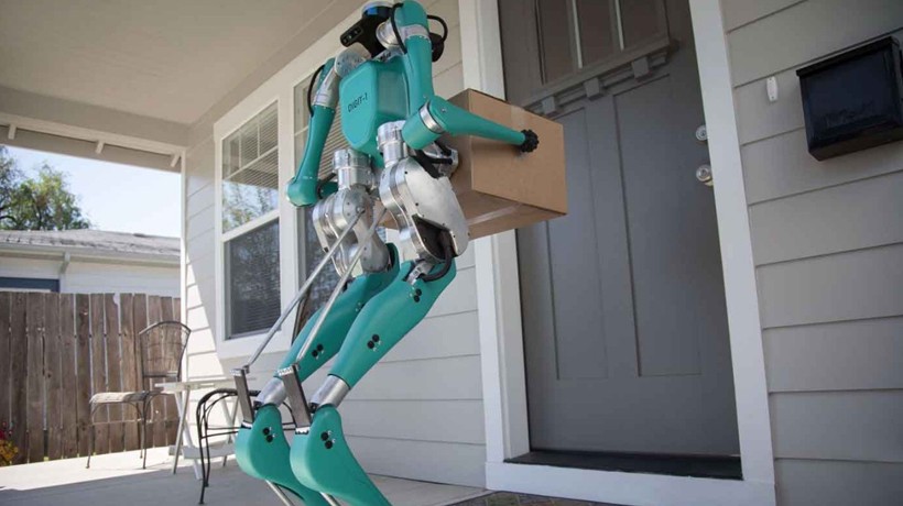 Robot Digit standing at door of house holding a box
