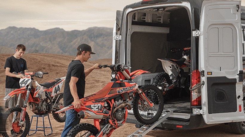 Image of people loading motorcycles into a Transit van