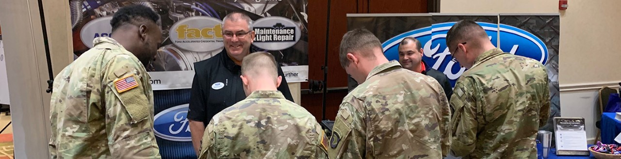 Image of group of soldiers listening to a presentation at a Ford booth