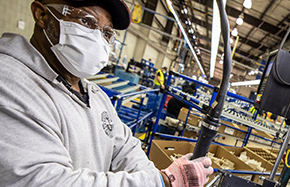 man wearing mask working at machine