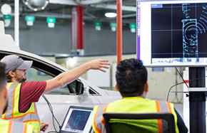 A group of men looking at a large computer screen