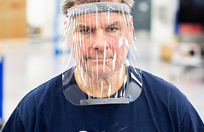 Male employee in blue shirt wearing face shield