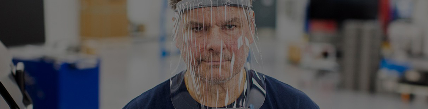 Male employee in blue shirt wearing face shield