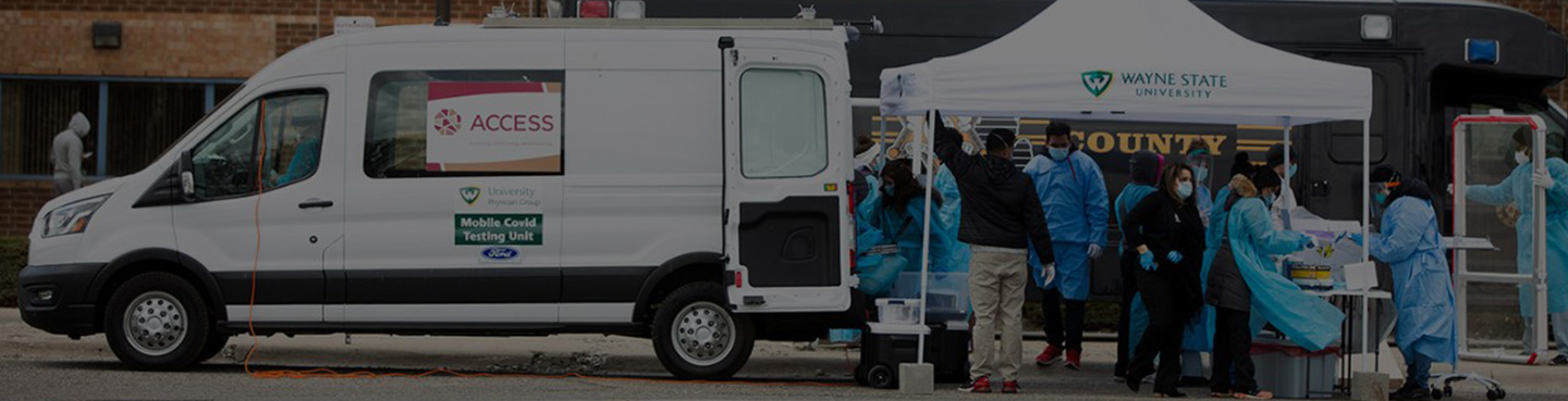 van and tent with badging and people getting tested for covid