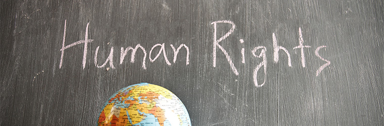 Human Rights written with chalk and a globe displayed in front