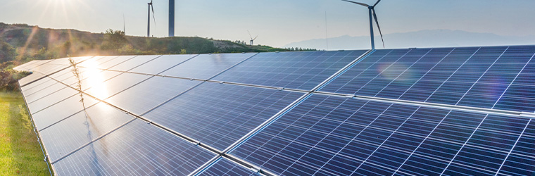Wind turbines behind solar panels