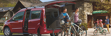 A family with their bikes standing next to their vehicle