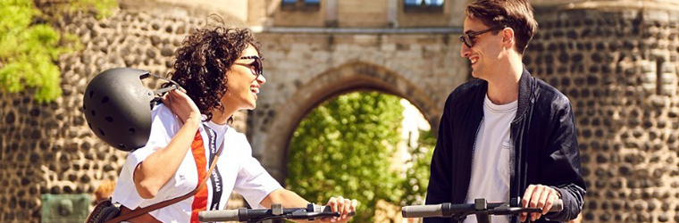 Two people talking to each other while holding their SPIN mobility scooters