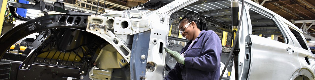 Woman working on frame of car
