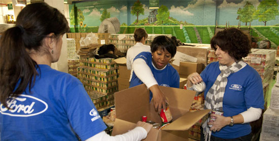 Ford volunteers pack food boxes.
