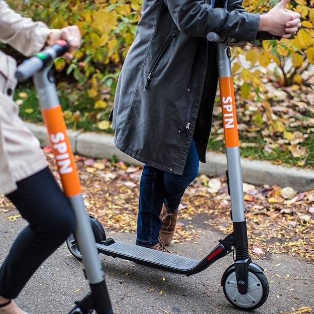 Two people on Spin scooters