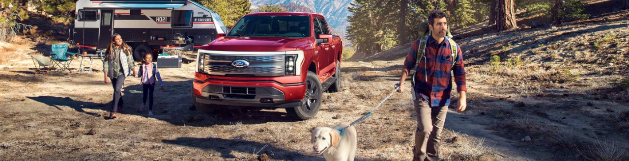 Family walking dog near ford truck at campsite