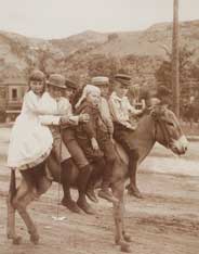 Image of: "Loaded," (children on a mule)