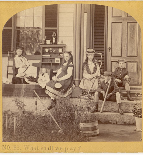 Image of children sitting on a porch with their toys.