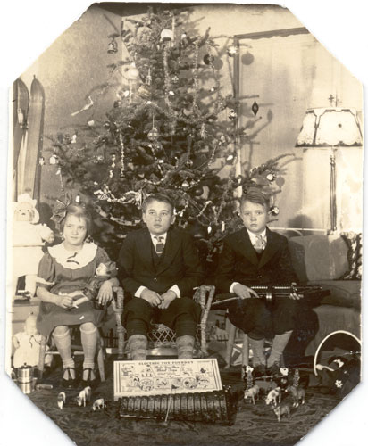 Image of three children in front of the christmas tree with an Electric Toy Foundry playset and other toys.