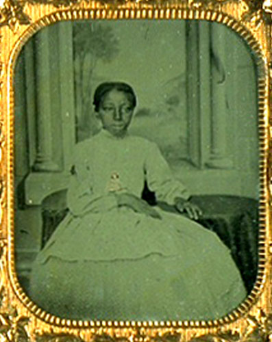 Image of a seated African American girl holding a doll on her lap.